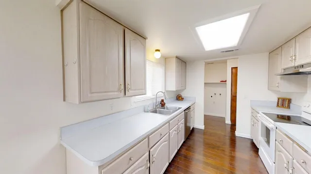 a kitchen with sink cabinets and wooden floor