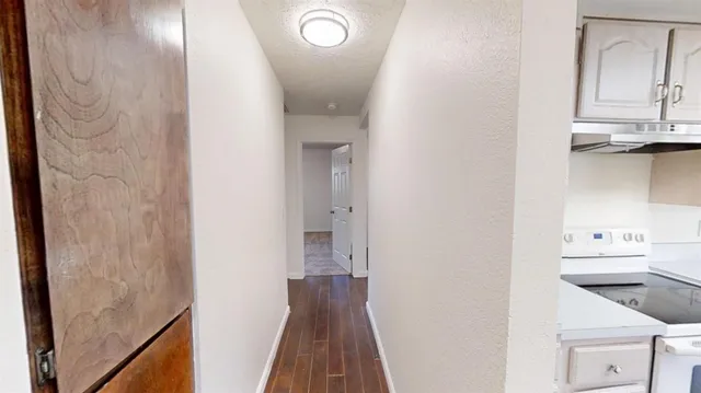 a view of a hallway with wooden floor