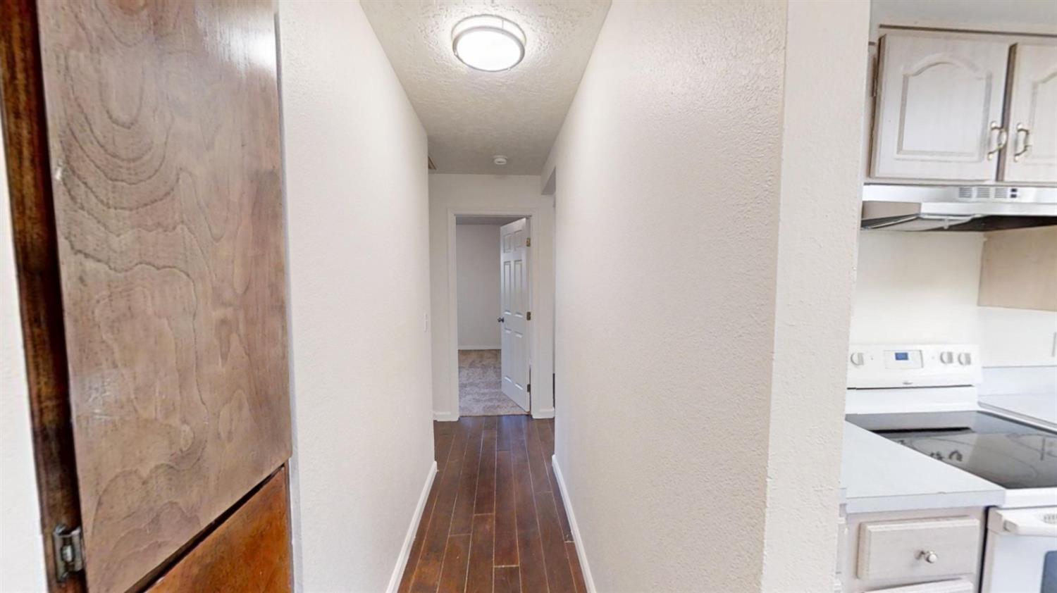 495 Pacific Street Coalinga, CA 93210 - Photo 9 of 33 a view of a hallway with wooden floor