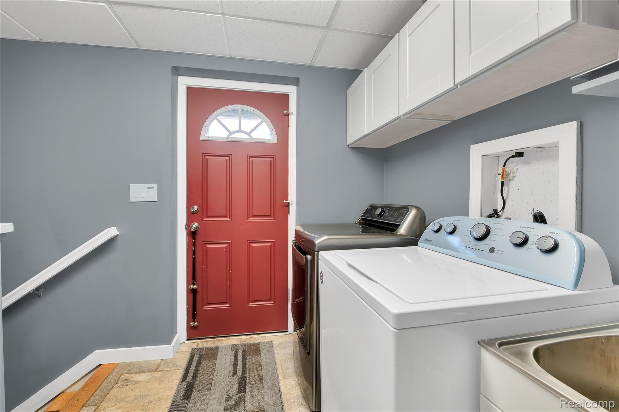 4853 Kidder Road Almont, MI 48003 - Photo 15 of 31 lower laundry room with door to outside and stairs down to attached garage