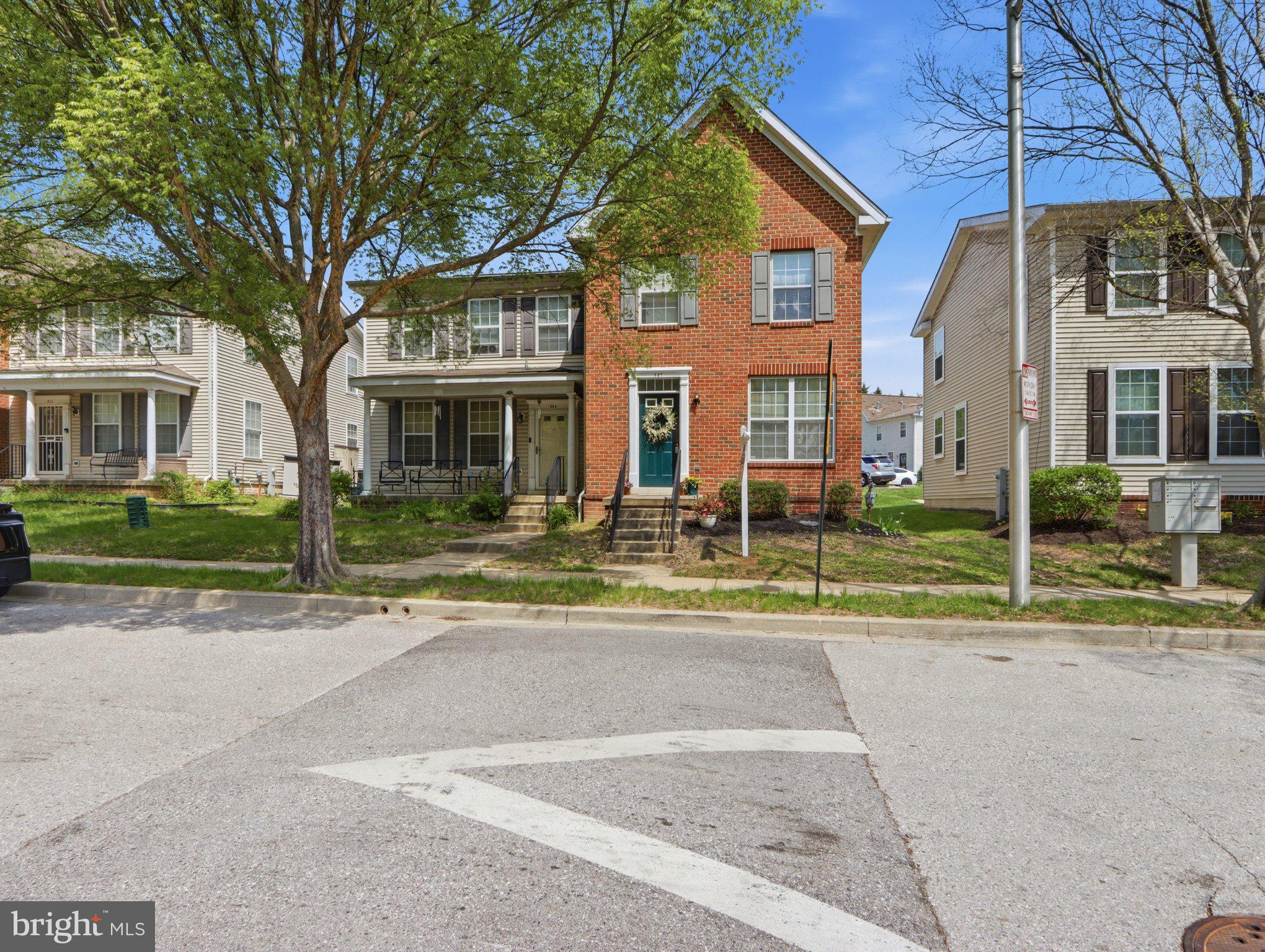907 Myrtle Avenue Baltimore, MD 21201 - Photo 3 of 28 a view of a white house with a small yard and large trees