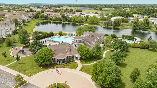 an aerial view of residential houses with outdoor space and lake view