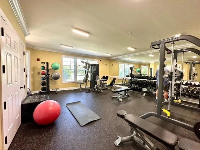 a room with gym equipment and wooden floor
