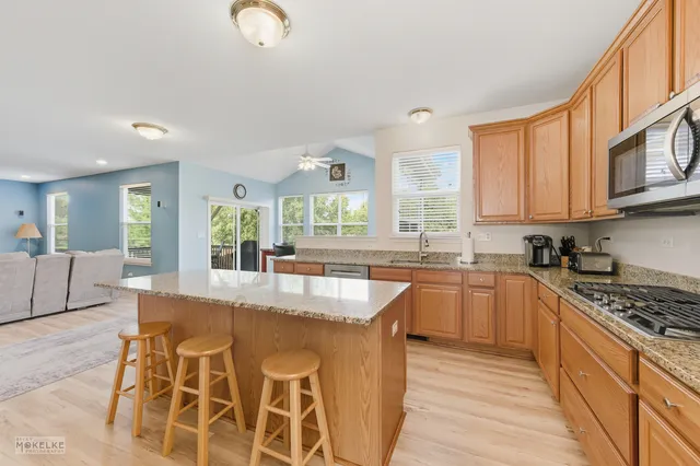 a kitchen with stainless steel appliances granite countertop a stove a sink and a granite counter tops with white cabinets