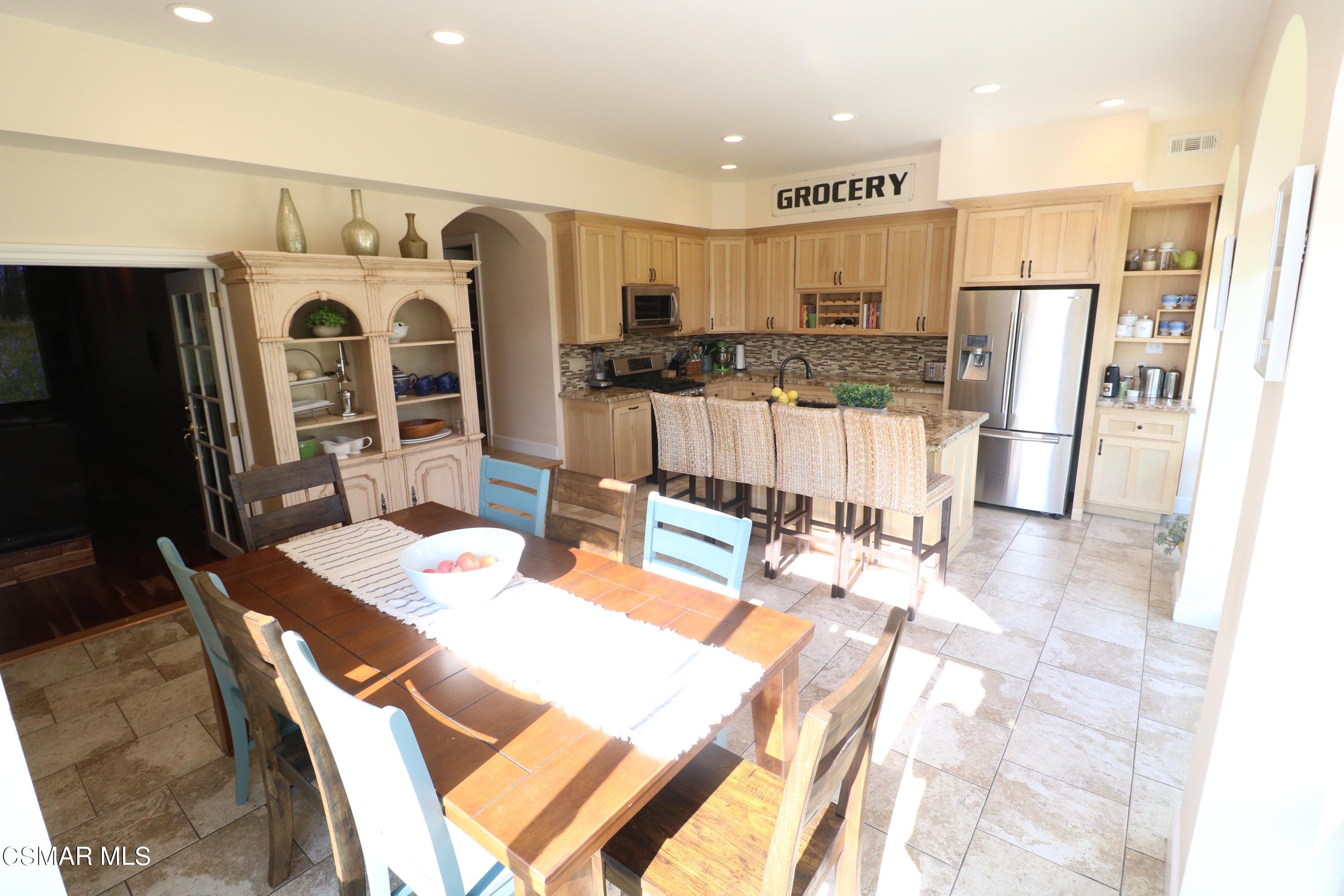 4608 Apricot Road Simi Valley, CA 93063 - Photo 7 of 37 a kitchen with stainless steel appliances refrigerator dining table and chairs