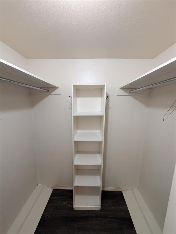 4715 Skillman Street, Unit A Dallas, TX 75206 - Photo 23 of 28 Walk-in closet featuring wood-finish flooring, white walls, built-in shelving, and dual clothing rods