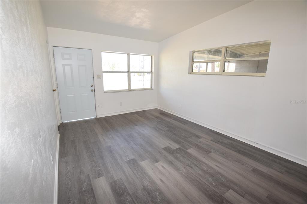 104 West Lancaster Road Orlando, FL 32809 - Photo 11 of 24 an empty room with wooden floor and windows