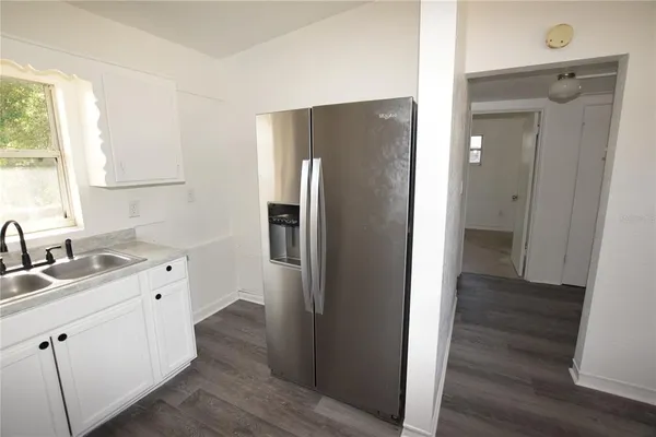 a kitchen with a refrigerator sink and cabinets