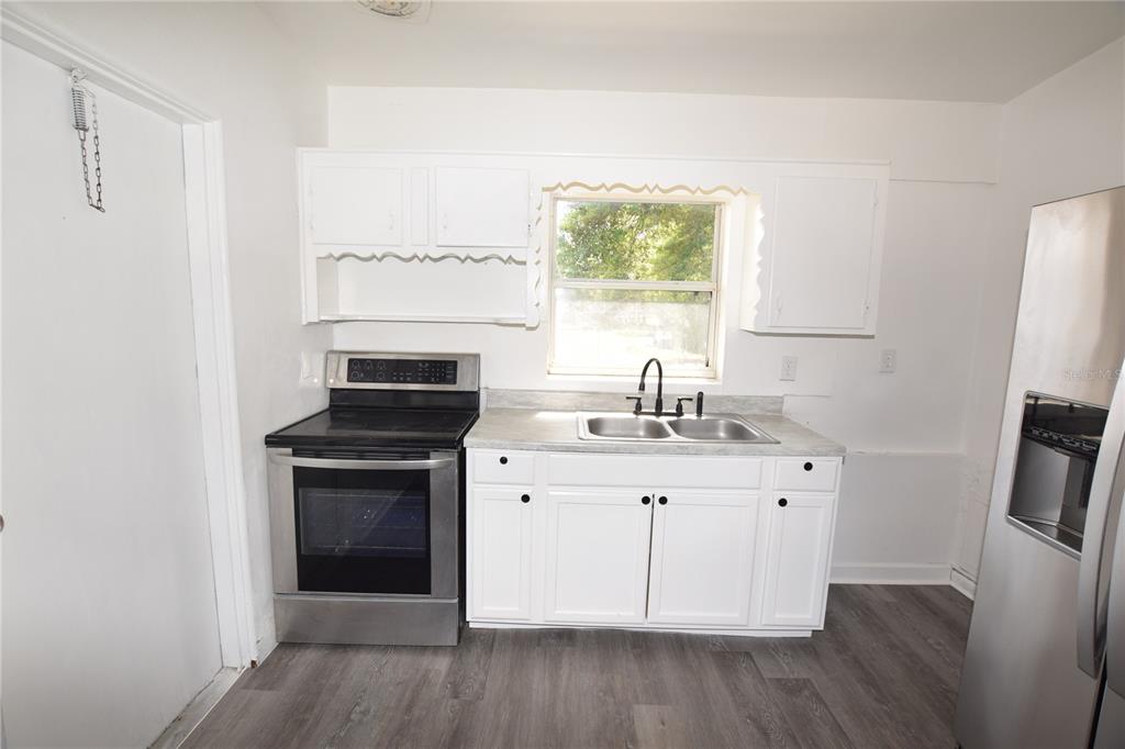 104 West Lancaster Road Orlando, FL 32809 - Photo 13 of 24 a kitchen with a sink stove and refrigerator