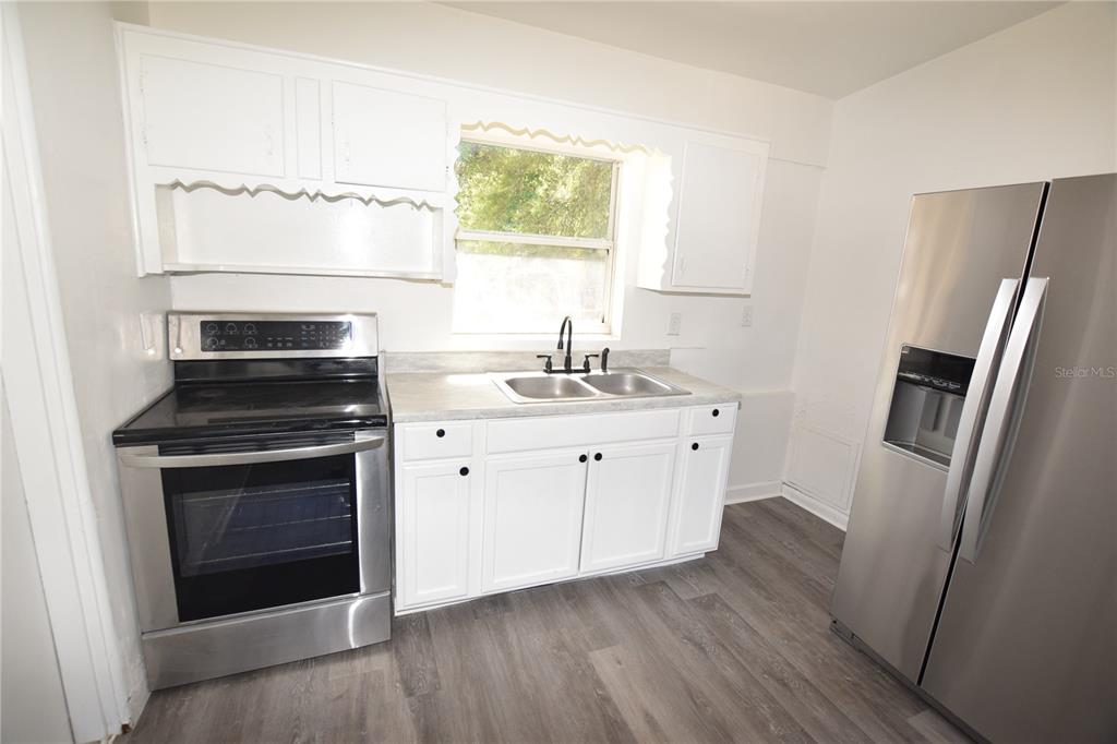 104 West Lancaster Road Orlando, FL 32809 - Photo 14 of 24 a kitchen with a sink stove and refrigerator