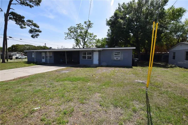 a front view of a house with a yard and trees