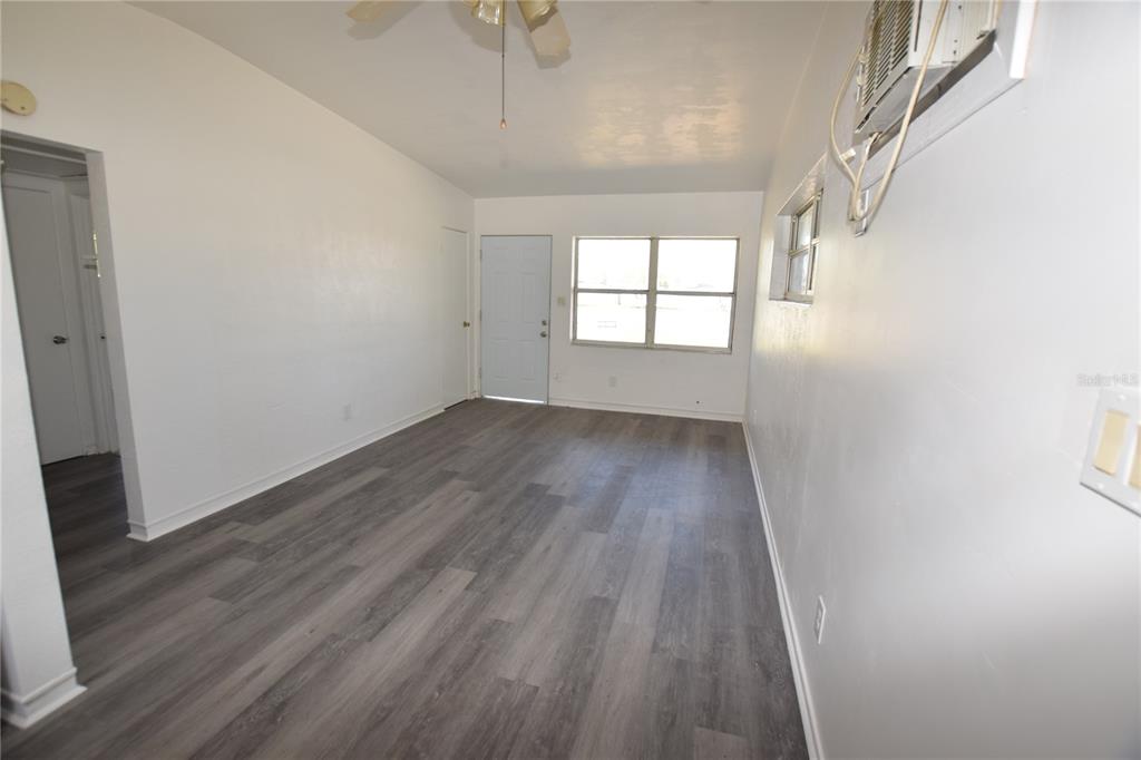 104 West Lancaster Road Orlando, FL 32809 - Photo 10 of 24 wooden floor in an empty room with a window