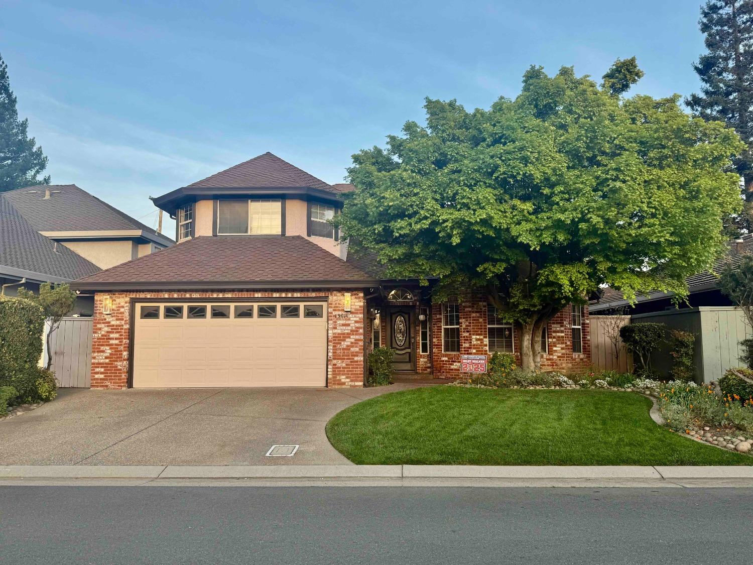 a front view of a house with a garden and plants