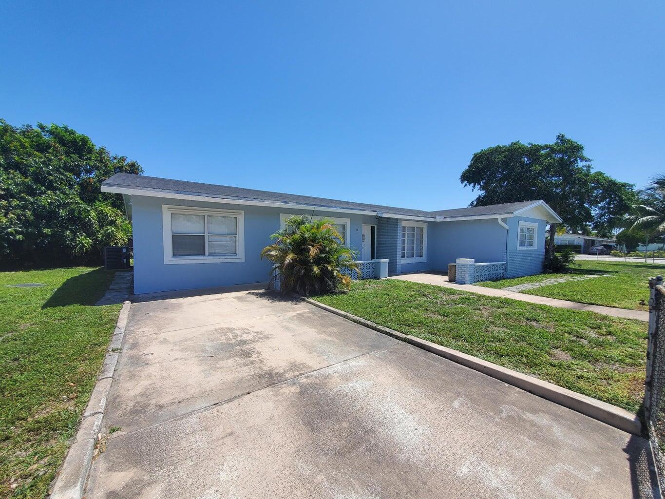 181 East Copans Road Pompano Beach, FL 33064 - Photo 2 of 11 a front view of a house with garden