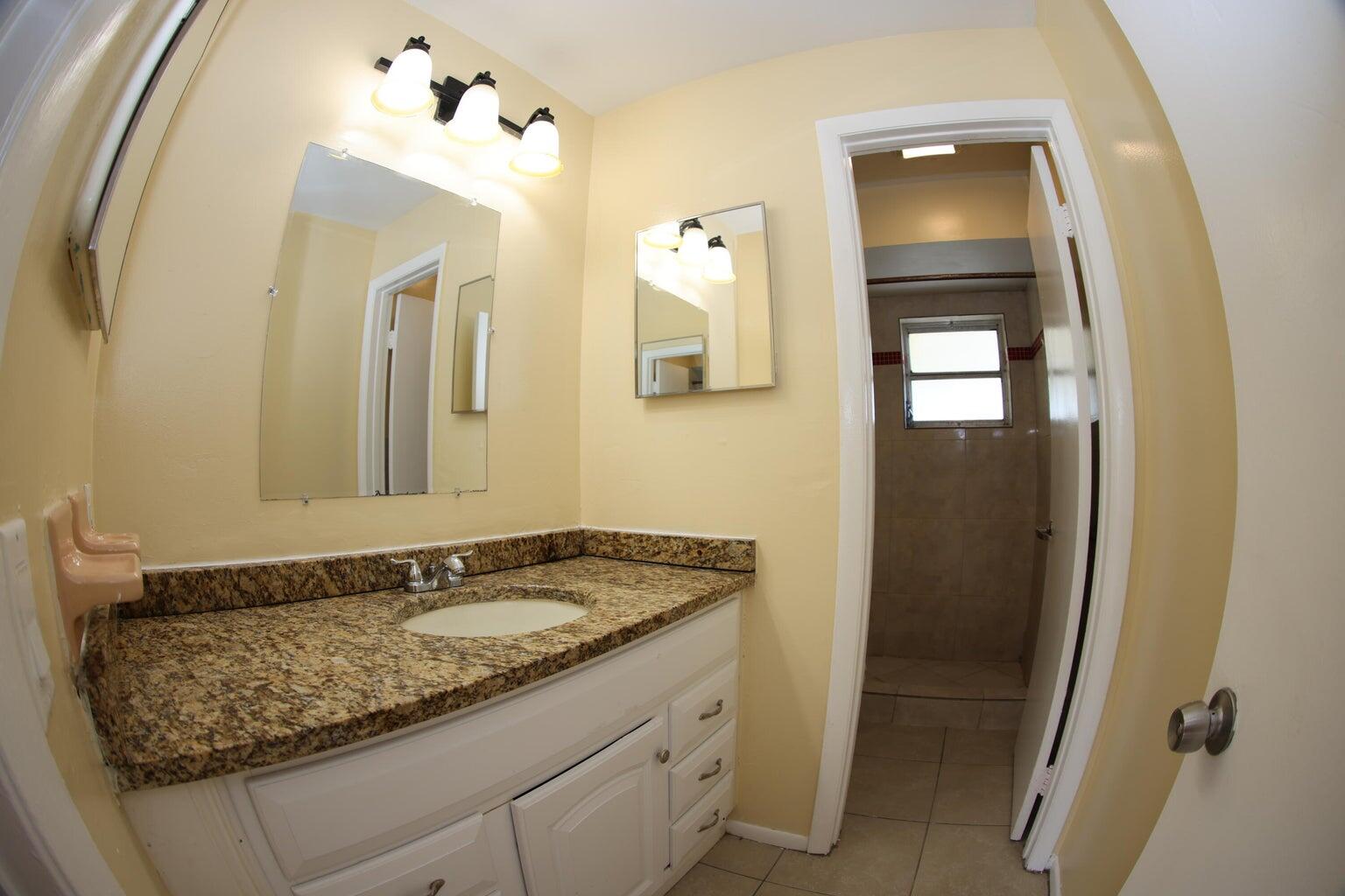181 East Copans Road Pompano Beach, FL 33064 - Photo 5 of 11 a bathroom with a granite countertop sink and a mirror