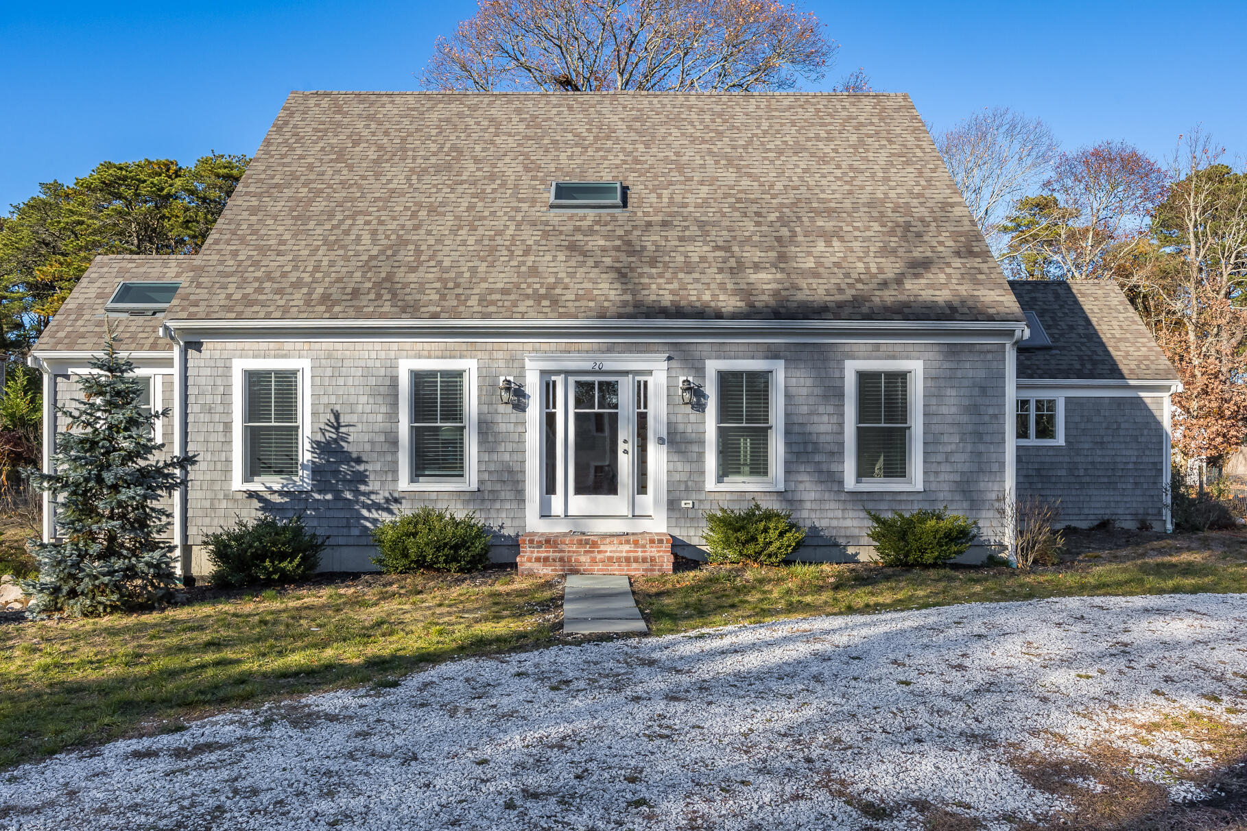 a front view of a house with garden and plants