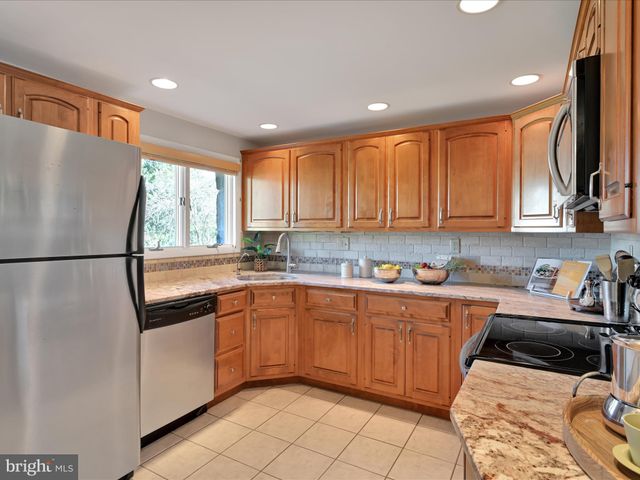 a kitchen with stainless steel appliances granite countertop a refrigerator sink and cabinets