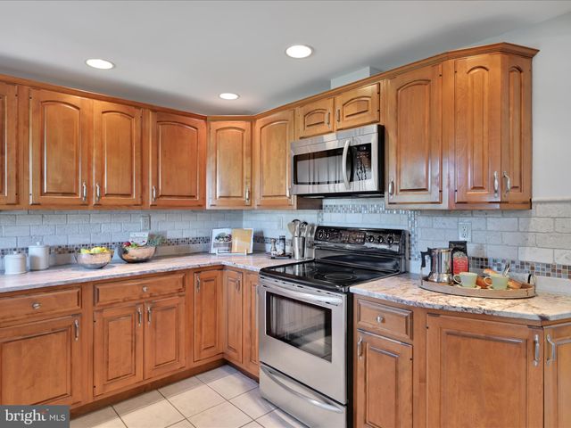 a kitchen with stainless steel appliances granite countertop a sink stove and microwave