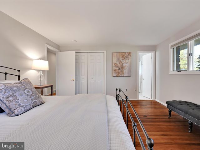 a bedroom with a bed and a dresser with rug