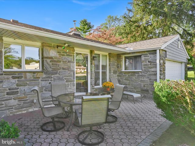 a view of a patio with couple of chairs and a potted plant