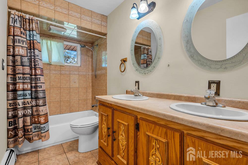 73 Webb Drive Fords, NJ 08863 - Photo 32 of 65 a bathroom with a granite countertop toilet a sink and a mirror