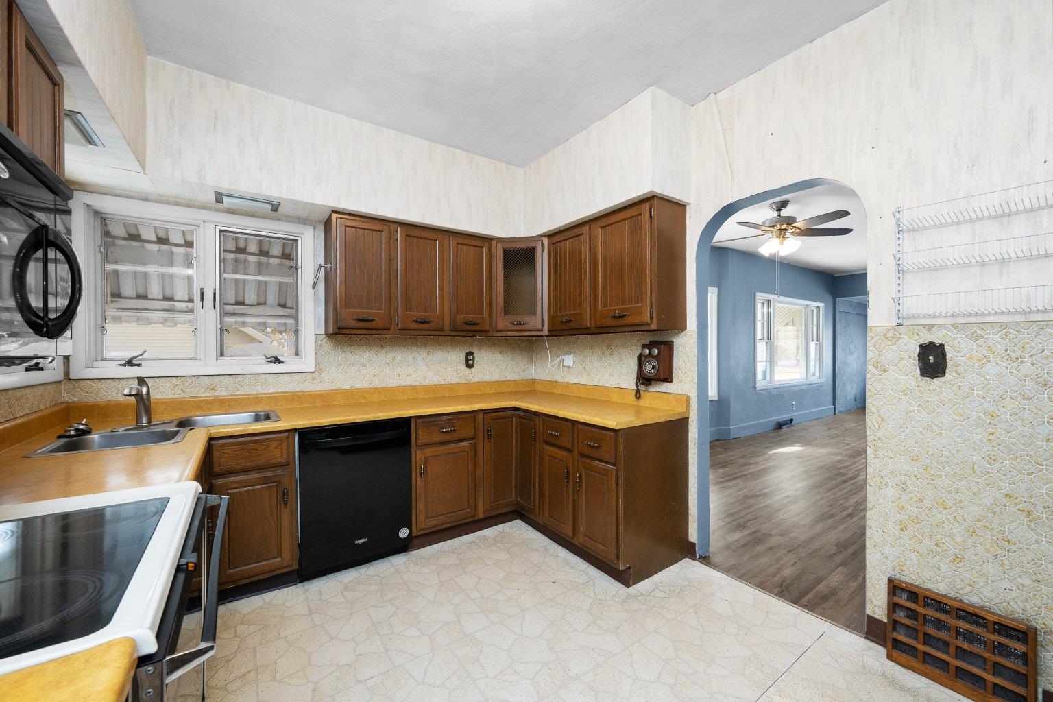 5108 6th Avenue Moline, IL 61265 - Photo 10 of 23 a kitchen with wooden cabinets a sink a stove and wooden floors