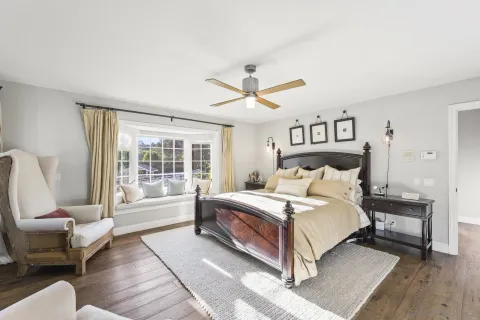 a bedroom with a bed and a ceiling fan
