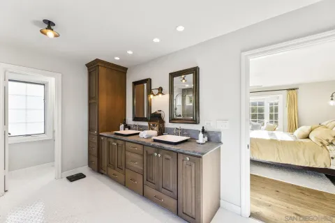 a spacious bathroom with a double vanity sink a mirror and a shower