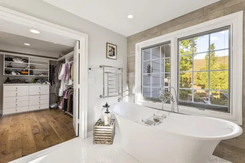 a spacious bathroom with a tub shower and windows