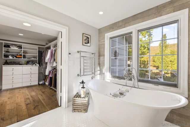 a spacious bathroom with a tub shower and windows