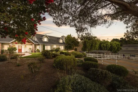 a view of a big house with a big yard and potted plants