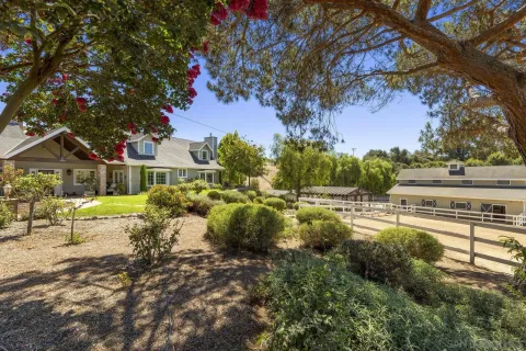 a view of a house with backyard and sitting area