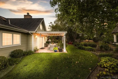 a view of a backyard with couches under an umbrella