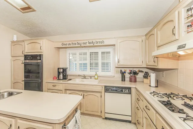 a kitchen with stainless steel appliances a stove a sink and a refrigerator