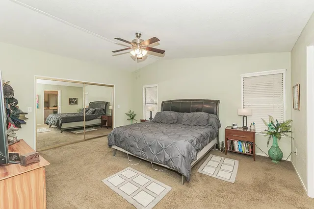 a bedroom with a large bed and a chandelier