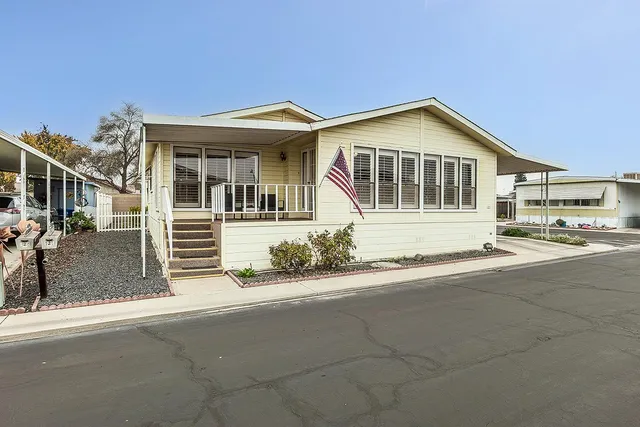 a view of a house with a yard and potted plants