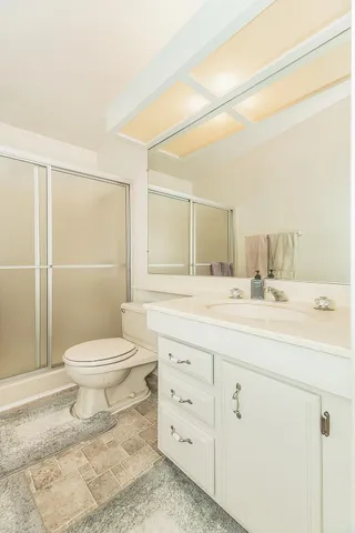 a bathroom with a sink a toilet and shower