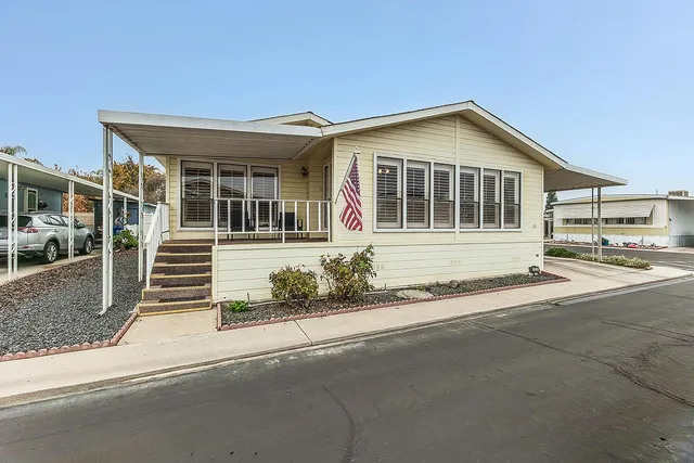 a front view of a house with a garden and parking