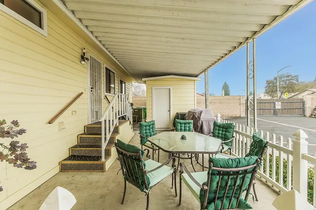 a view of a patio with table and chairs with wooden floor and fence
