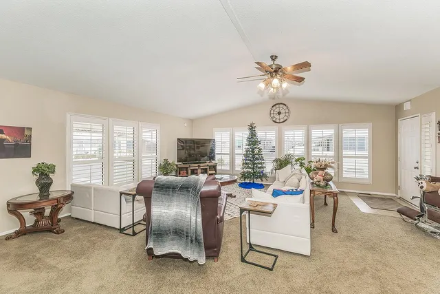 a living room with fireplace furniture and a large window