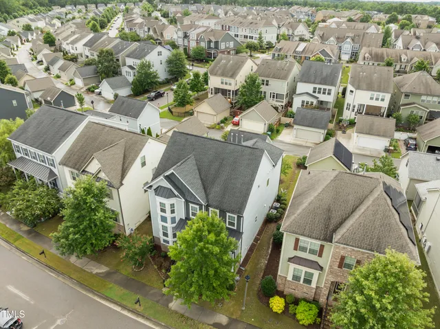 an aerial view of a residential apartment building with a yard and parking spaces