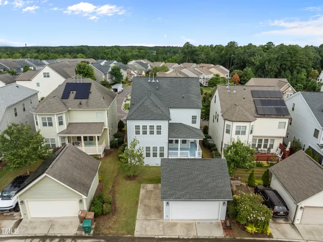an aerial view of multiple houses with a yard