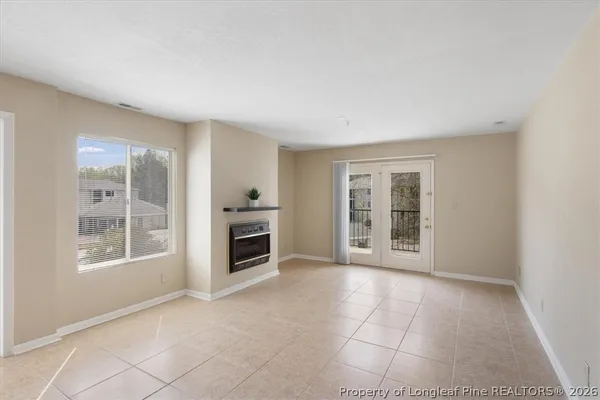 a view of an empty room with a fireplace and a window