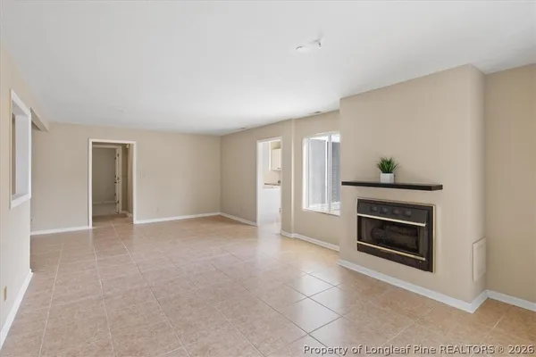 a view of an empty room with a fireplace and a window