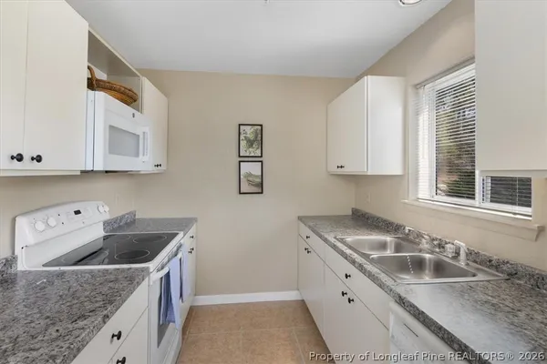 a kitchen with a sink a stove a refrigerator and cabinets