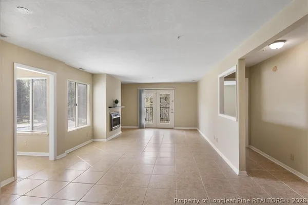 a view of an empty room with a fireplace and a window