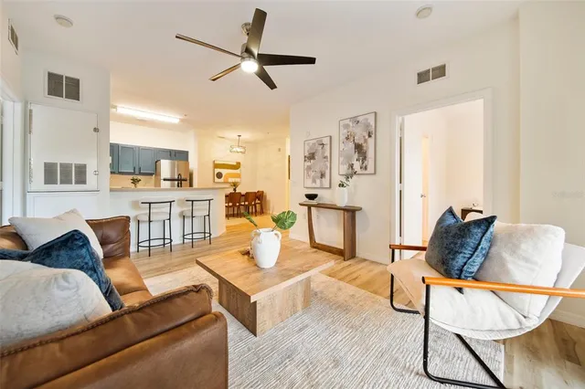 a living room with furniture and a view of kitchen