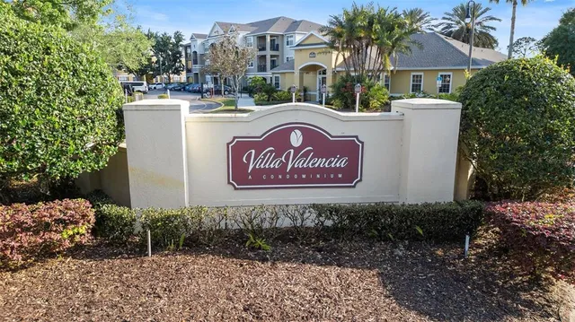 a sign board with a small yard and large trees