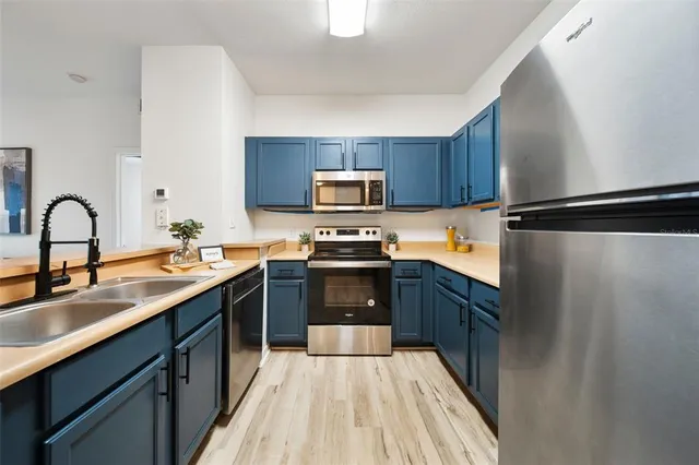 a kitchen with granite countertop a refrigerator stove and sink