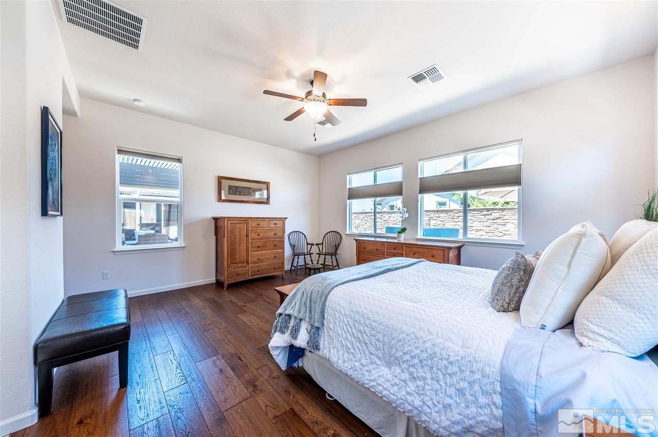 9845 Shadowless Trail Reno, NV 89521 - Photo 16 of 40 a bedroom with a large bed and a chandelier